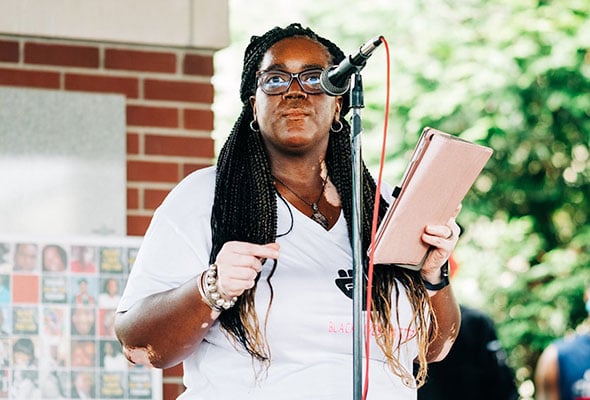 Deatrea Rose speaks in front of a microphone at a local Black Lives Matter event.