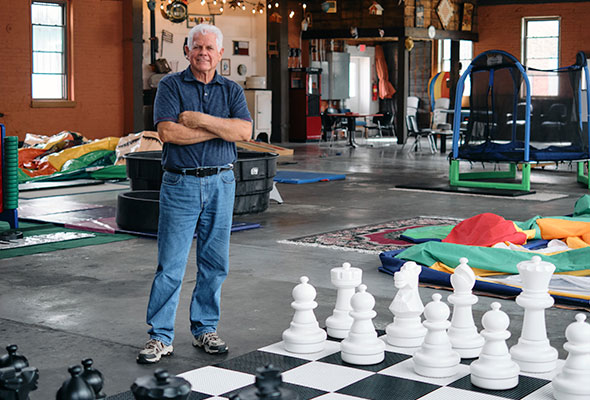 Larry Fields stands in front of an oversized chess set.