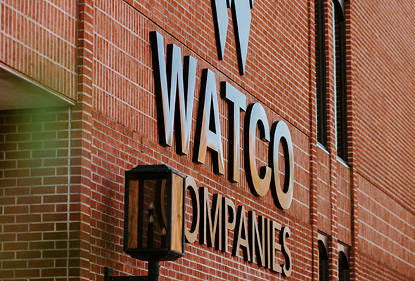 Watco Companies building is shown, their sign attached to a long brick facade.