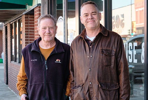 Two men standing outside coffee shop
