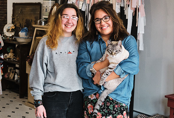 Two women smiling and cat
